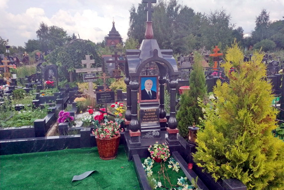 Фотокерамика покойного на пьедестале под сводом резной арки