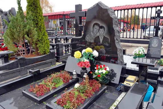 Семейный памятник отцу и сыну с цветниками и небольшим столиком
